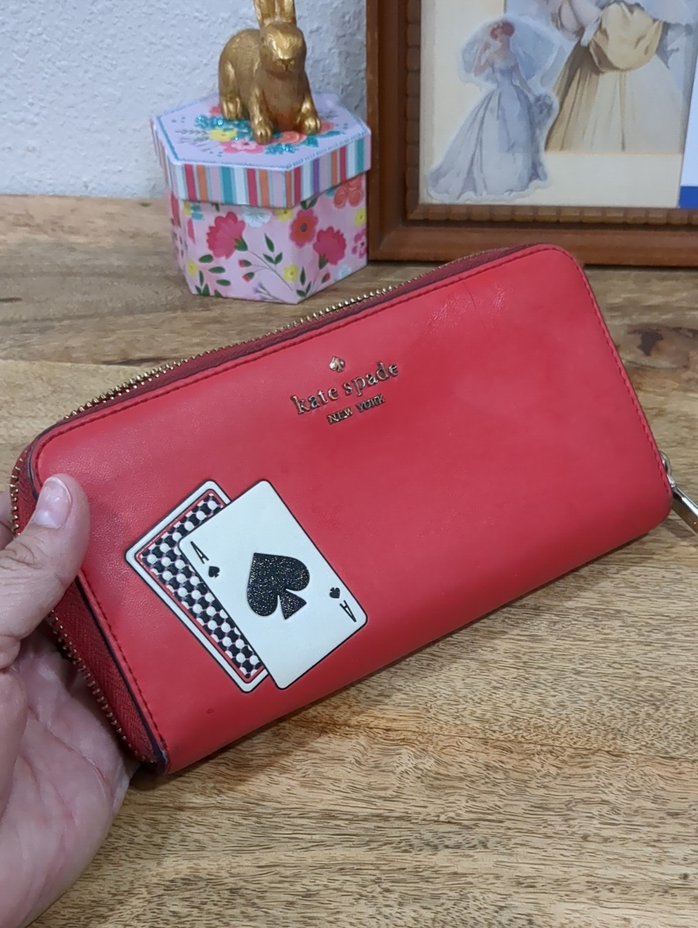 Kate Spade red zip-around wallet with Ace of Spades patch